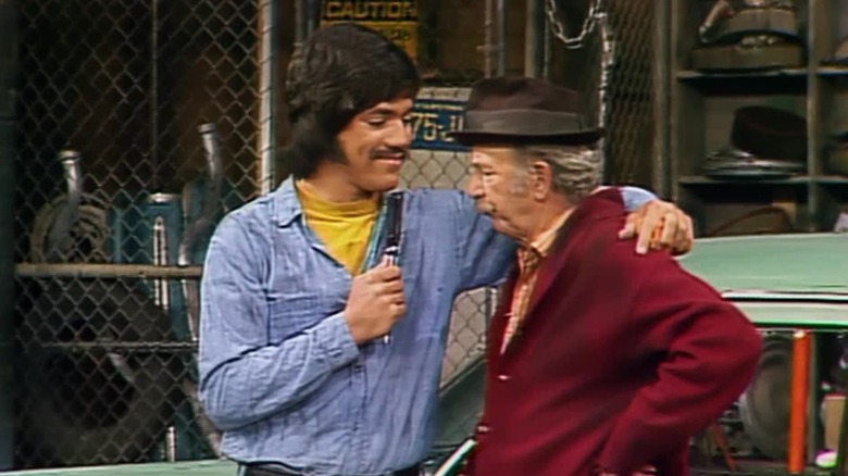 Chico Rodriguez (Freddie Prinze) grins at Ed Brown (Jack Albertson) while putting his arm around him in Chico and the Man