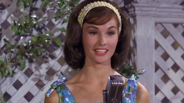 Bobbie Jo Bradley (Lori Saunders) sings into a microphone by an ivy wall in Petticoat Junction