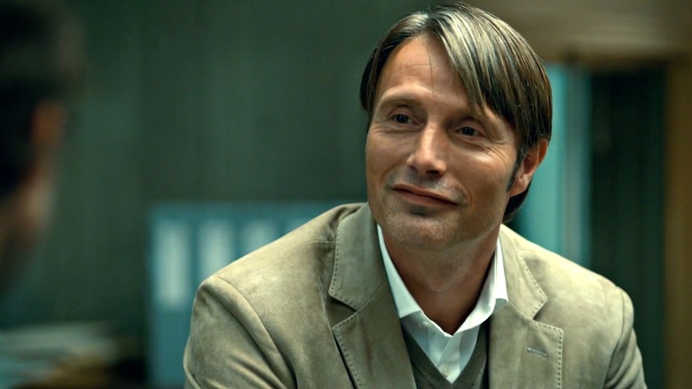 Hannibal Lecter (Mads Mikkelsen) grins slyly in Hannibal