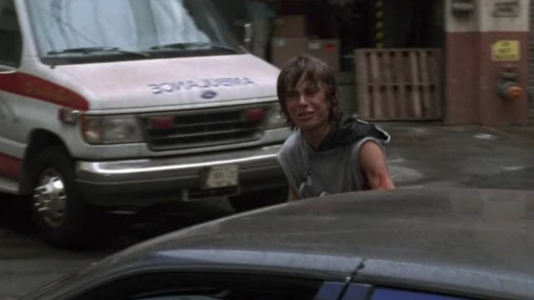 Bobby Neville cries behind a car in ER