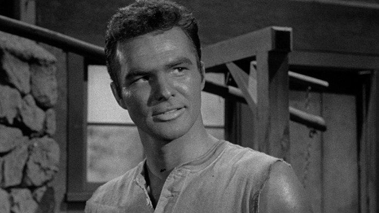 A sweaty Quint Asper (Burt Reynolds) smirks in Gunsmoke