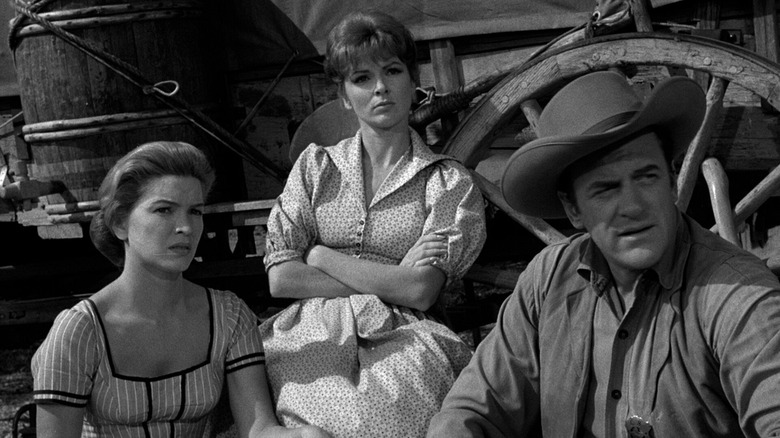 Polly Mims (Ellen Burstyn) and Matt Dillon (James Arness) stand by a wagon with another woman in Gunsmoke