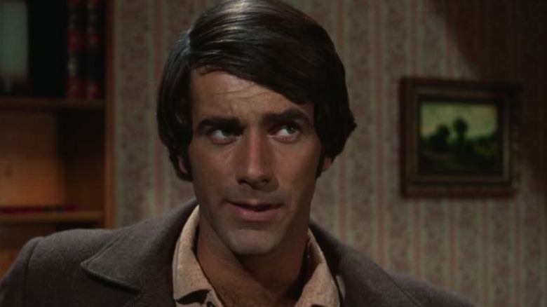 Cory Soames (Sam Elliott) eyes someone cautiously in Gunsmoke