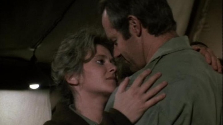 Carrie Donovan (Ann Sweeny) leans in to kiss BJ Hunnicutt (Mike Farrell) in M*A*S*H