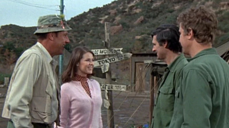 Henry Blake (McLean Stevenson) introduces Nancy Sue Parker (Katherine Baumann) to Hawkeye Pierce (Alan Alda) and Trapper John McIntyre (Wayne Rogers) in M*A*S*H
