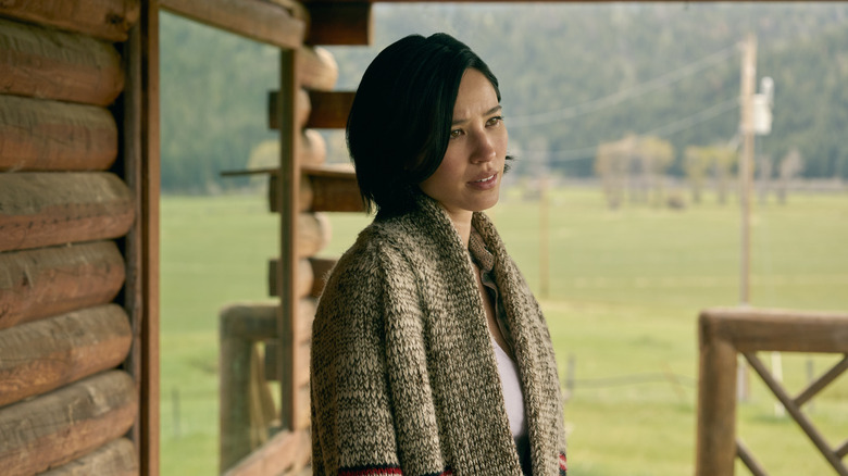Kelsey Asbille's Monica Dutton standing on a porch on Yellowstone