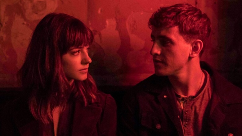 Daisy Edgar-Jones and Paul Mescal as Marianne and Connell looking at each other in red light in Normal People