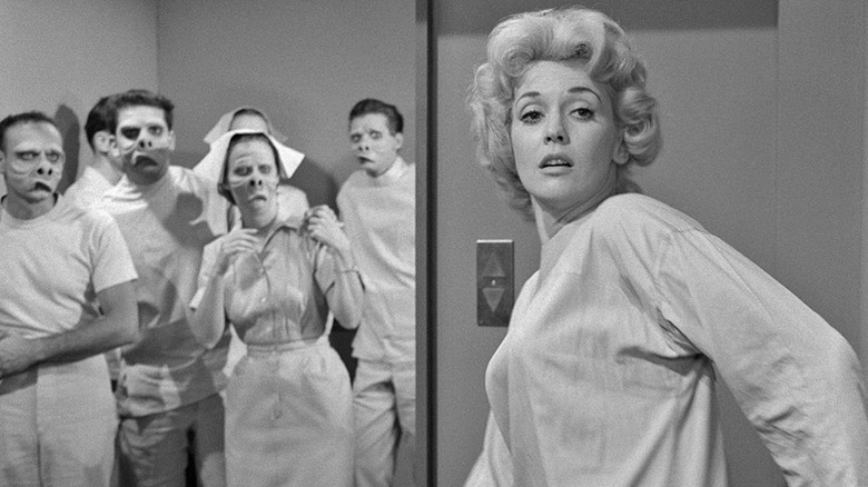 Jane Tyler (Maxine Stuart) stands in front of a group of grotesque humanoids in The Twilight Zone (1959)