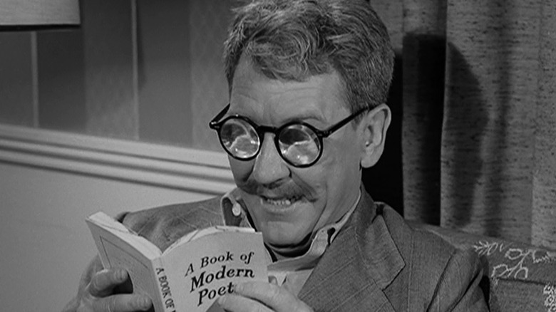 Henry Beamis (Burgess Meredith) happily reads a paperback book through his thick glasses in The Twilight Zone (1959)