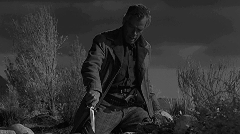 Conny stabbing a knife into the dirt