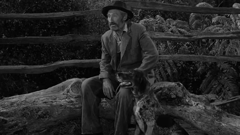 Hyder sitting with his dog on a log