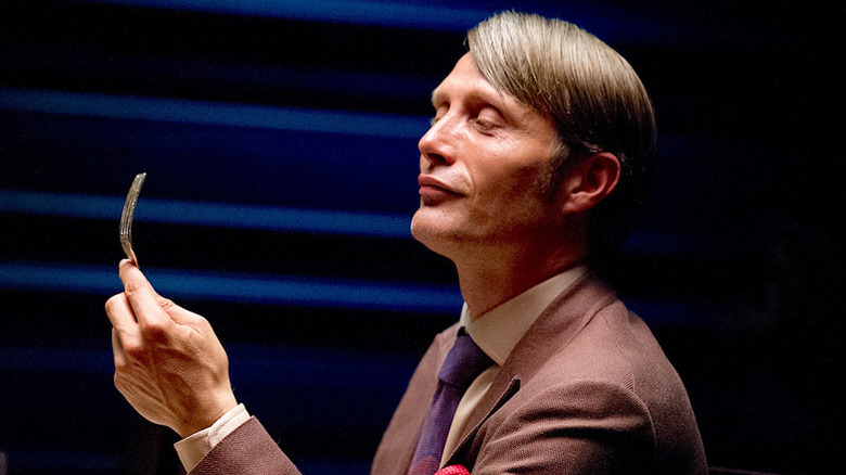 Hannibal Lecter (Mads Mikkelsen) holding a fork on "Hannibal."