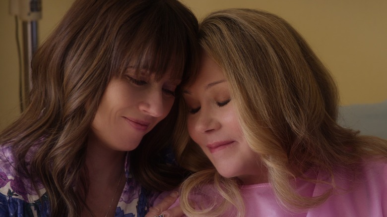 Judy and Jen tilt their heads toward each other, softly smiling, in "Dead to Me."