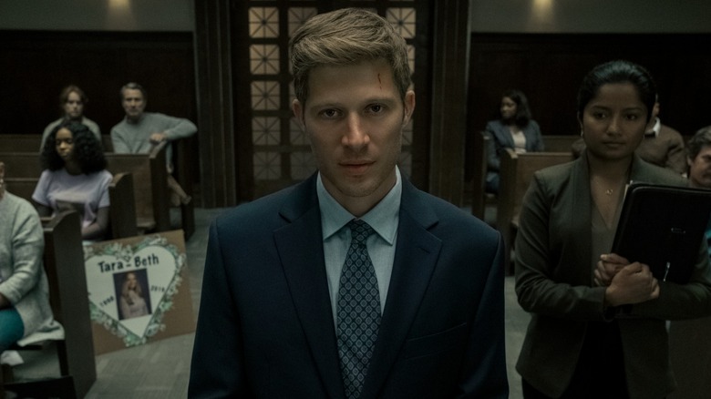 Riley Flynn stands in a courtroom in "Midnight Mass."