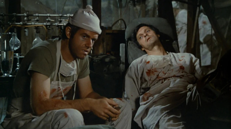 B.J. Hunnicut (Mike Farrell) and Hawkeye Pierce (Alan Alda) sit utterly exhausted in M*A*S*H