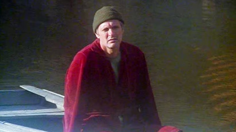 Hawkeye Pierce (Alan Alda) sits armless in a boat in M*A*S*H