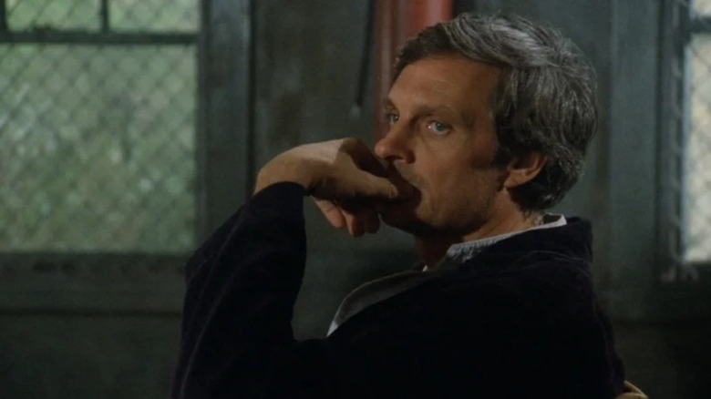 Hawkeye Pierce (Alan Alda) sits pensively in M*A*S*H