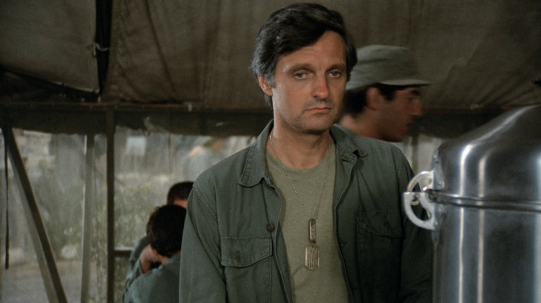 Hawkeye Pierce (Alan Alda) stands troubled in the mess hall in M*A*S*H