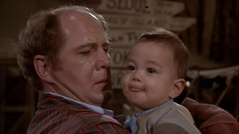 Charles Winchester (David Ogden Stiers) holds a baby in M*A*S*H