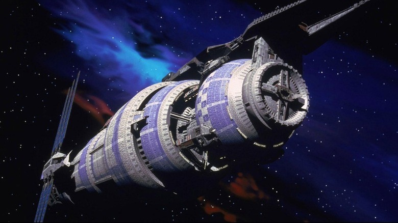 The Babylon 5 cruises before a blue nebula in Babylon 5