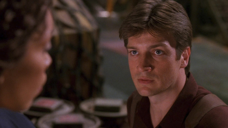 Mal Reynolds (Nathan Fillion) looks up at Zoe Washburne (Gina Torres) in Firefly