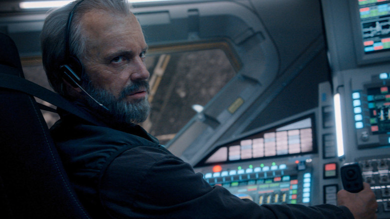 An older Ed Baldwin (Joel Kinnaman) looks back from a shuttle steering console in For All Mankind