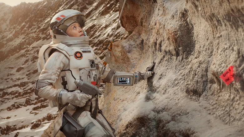 Kelly Baldwin (Cynthy Wu) looks up from a cliff face while wearing a space suit in For All Mankind