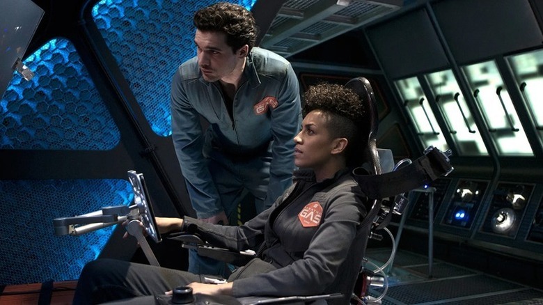 James Holden (Steven Strait) leans over Naomi Nagata (Dominique Tipper) as she sits in a pilot's chair in The Expanse