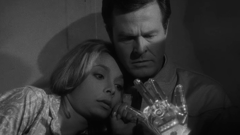 Consuelo Biros (Arlene Martel) and Trent (Robert Culp) examine a glass hand with visible circuitry in The Outer Limits (1963)