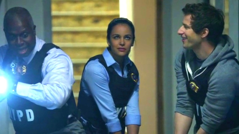 Andre Braugher, Melissa Fumero, and Andy Samberg as Holt, Amy, and Jake wearing tactical gear in Brooklyn Nine-Nine