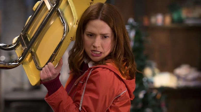 Kimmy holding a chair above her head in Unbreakable Kimmy Schmidt