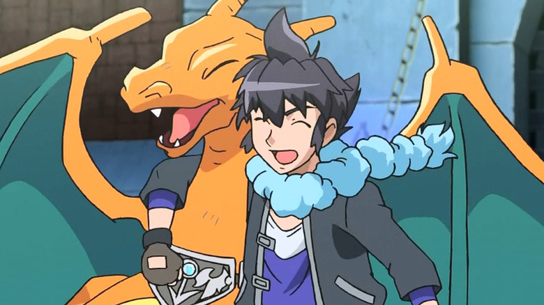 Alain with his arm around his Charizard smiling