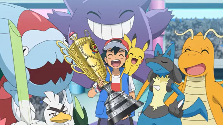 Ash Ketchum holding a trophy surrounded by Sirfetch'd, Dracovish, Gengar, Pikachu, Lucario, and Dragonite in the Pokemon anime