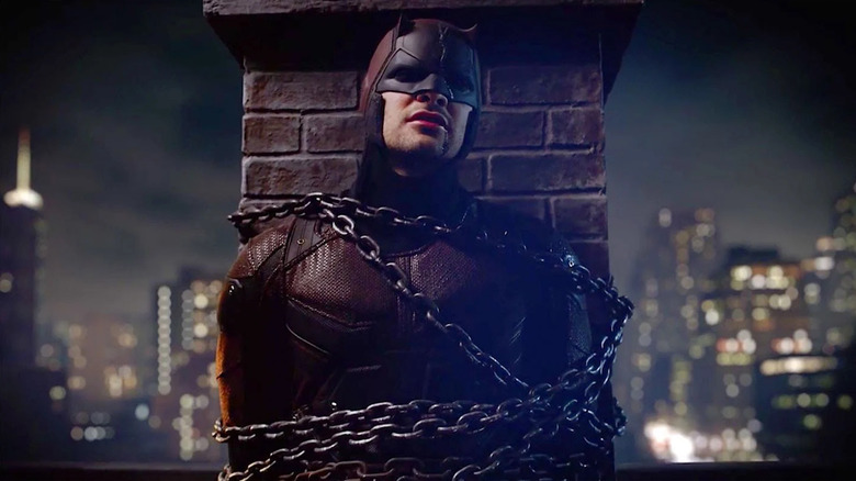 Matt Murdock wearing the Daredevil costume and chained to a chimney in Daredevil