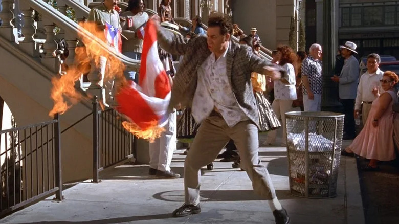 Michael Richards as Kramer waving burning Puerto Rican flag on sidewalk on Seinfeld