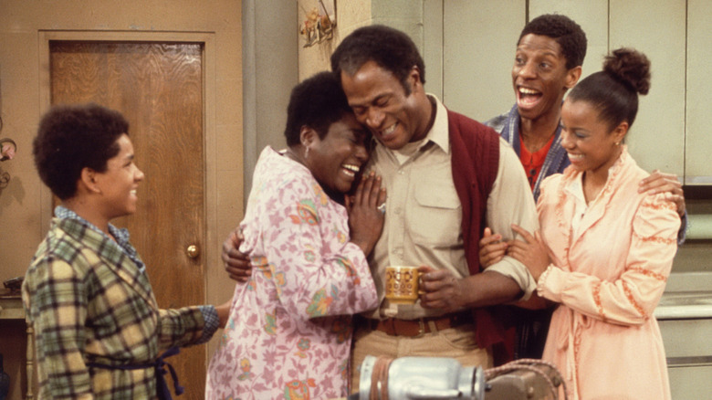 James Evans Sr., Michael, Florida, JJ, and Thelma embracing excitedly in Good Times