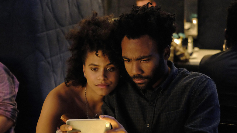 Earnest (Donald Glover) and Vanessa (Zazie Beetz) look at the phone in Atlanta