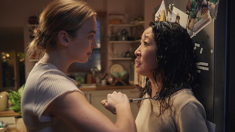Jodie Comer as Villanelle holding knife to Sandra Oh as Eve's throat against the fridge in Killing Eve