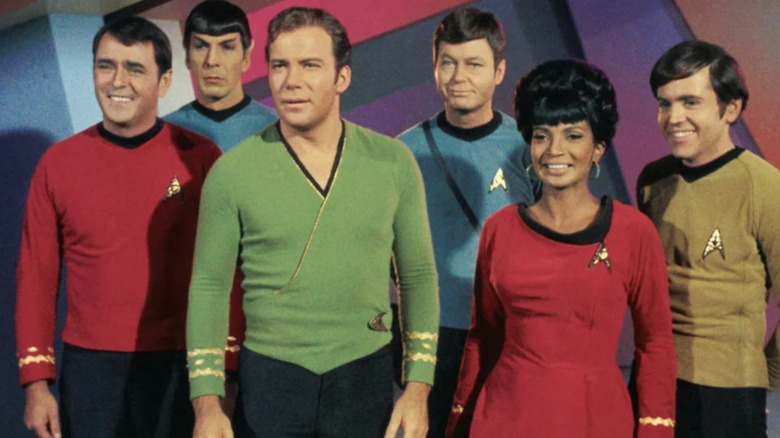 James Doohan as Montgomery "Scotty" Scott, Leonard Nimoy as Spock, William Shatner as James T. Kirk, DeForest Kelley as Dr. Leonard "Bones" McCoy, Nichelle Nichols as Nyota Uhura, and Walter Koenig as Pavel Chekov standing together in Star Trek: The Original Series