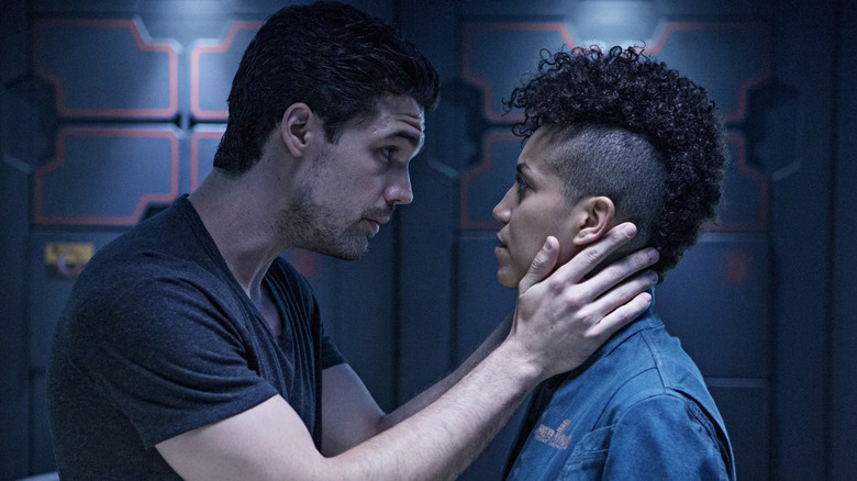 Steven Strait as James Holden holding the face of Dominique Tipper as Naomi Nagata in The Expanse