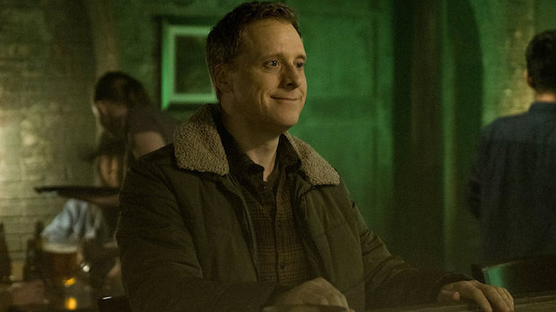 Alan Tudyk as Henry standing at bar in Resident Alien
