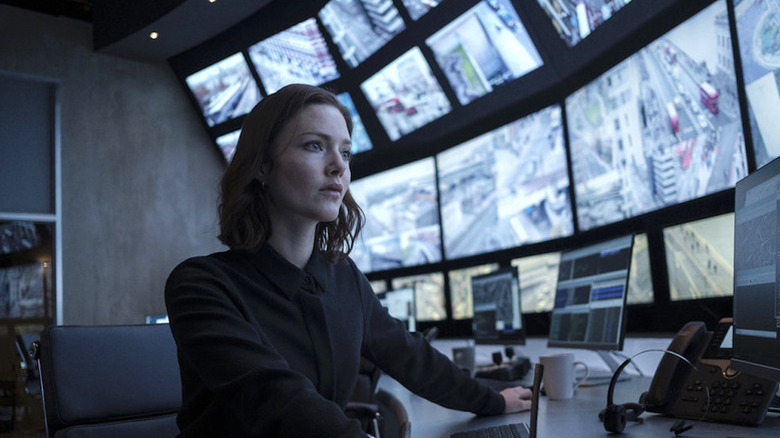 Holliday Grainger as Rachel sitting in front of CCTV screens in The Capture