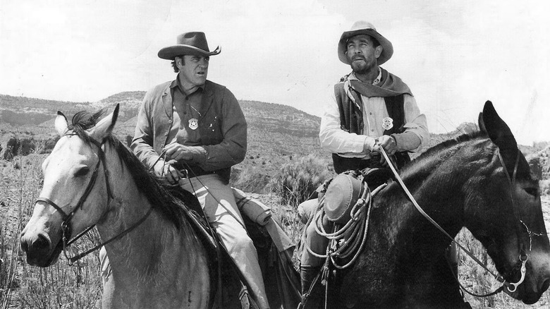 Marshal Matt Dillon (James Arness) and Festus (Ken Curtis) on horseback outside in Gunsmoke