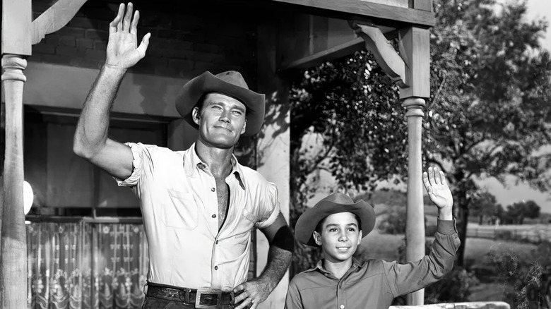 Chuck Connors as Lucas McCain waves with Johnny Crawford as his son Luke on The Rifleman