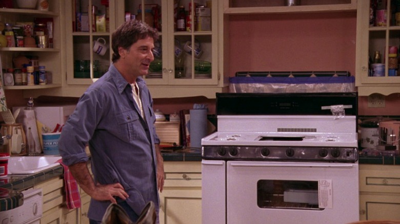 Gianni standing next to the new stove on Everybody Loves Raymond S8E5