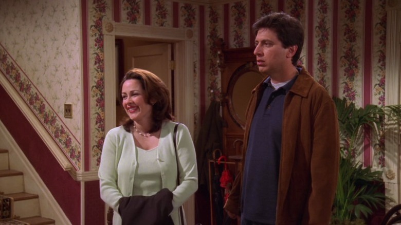 Debra and Ray standing side by side at the reception with only Debra smiling on Everybody Loves Raymond S3E21
