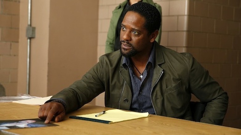 Blair Underwood as Robert Ironside sitting at table in Ironside