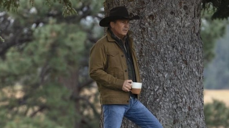 John (Kevin Costner) standing next to a tree on "Yellowstone."