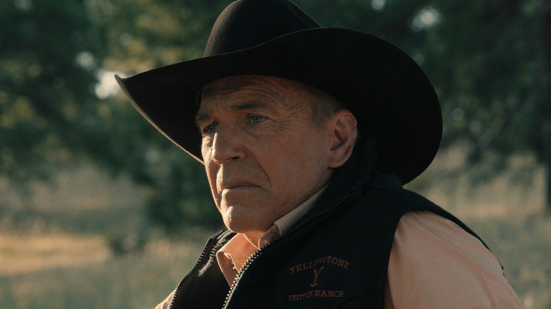 John Dutton (Kevin Costner) sitting in the grass on "Yellowstone."