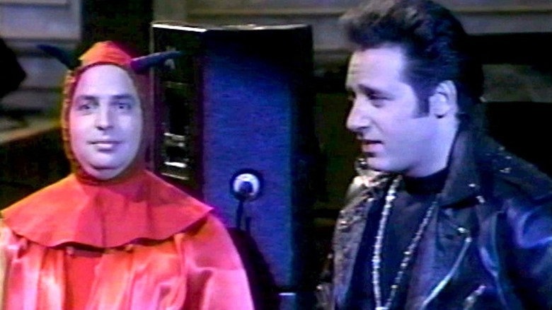 Jon Lovitz dressed as the devil standing next to Andrew Dice Clay on SNL